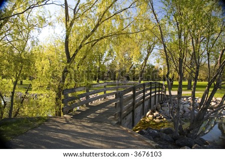 Old wooden bridge over water, in a city park.