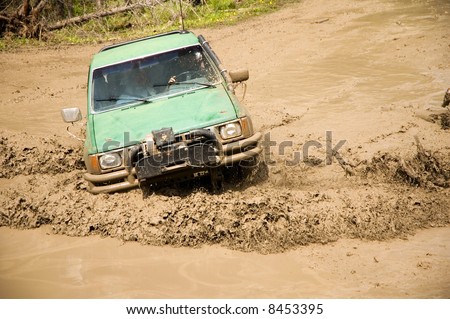4x4 with a snorkel plowing through a mud hole.