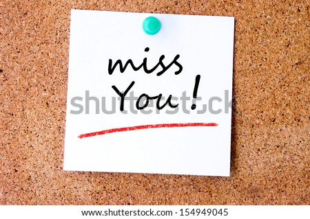 Miss you, written on an white sticky note pinned on a cork bulletin board.