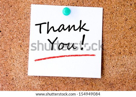 Thank You on white sticky note pinned with blue push pin on cork board