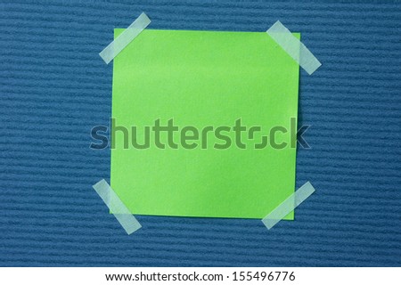 A blank sticky note with a notebook on the wall
