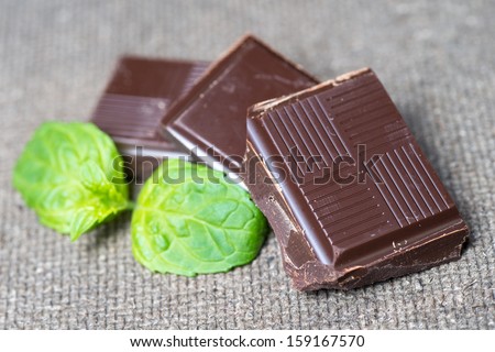 stack of chocolate pieces with a leaf of mint