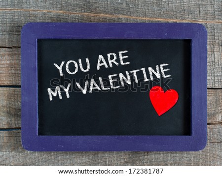 Valentines message on an old retro school slate in a rustic weathered wooden frame saying - You are my Valentine - under a simple hand drawn outline of a heart for a heartfelt tender greeting