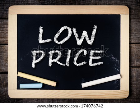 Low price handwritten with white chalk on a blackboard on wood background