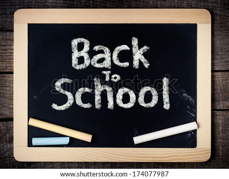 Back to School handwritten on blackboard with chalk on wooden background
