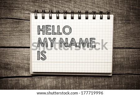 Name tag HELLO my name is on white pper on wooden background
