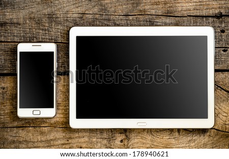 White Tablet and Smart phone. Mobile phone and Tablet pc on wooden table