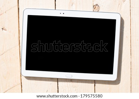 Tablet touch computer gadget with isolated screen on a background of wood