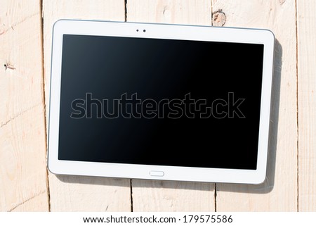 Tablet touch computer gadget with isolated screen on a background of wood