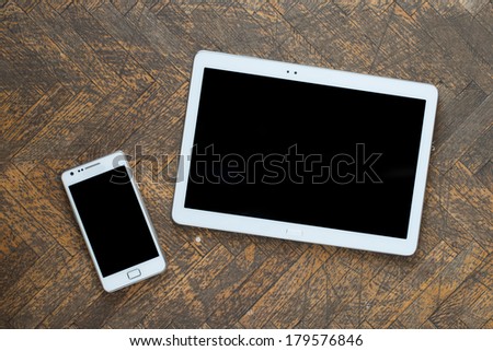 White Tablet and Smart phone. Mobile phone and Tablet pc on wooden floor