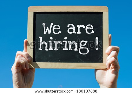 Woman holding blackboard with text We are hiring !