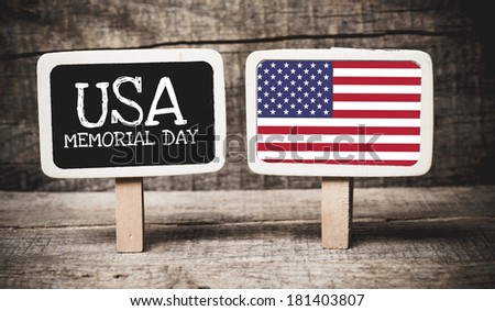 Memorial Day holiday sign written on a chalkboard with American flag on wooden background