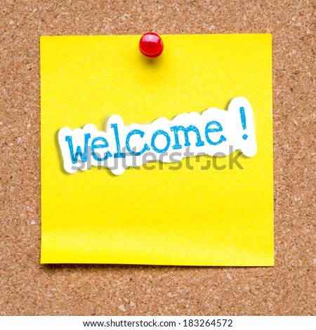 Welcome word written on paper and pinned on cork board