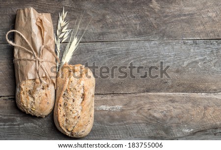 Delicious bread packed in paper on a wood table