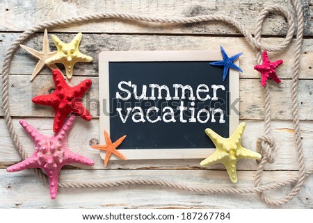 Sea travel frame decor with seashells and rope over wooden background with blackboard nad text Summer vacation on it