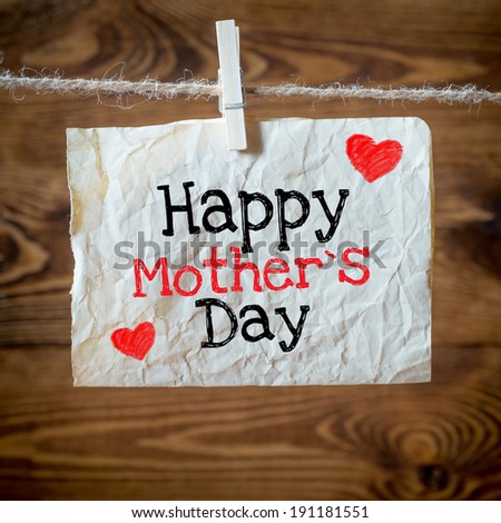 Happy mothers Day message written on a aged paper handling on rope with hearts