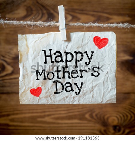 Happy mothers Day message written on a aged paper handling on rope with hearts