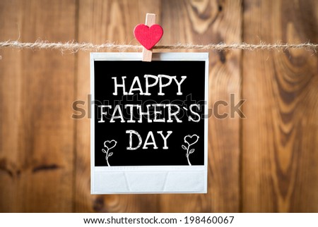 Happy Father`s Day message written on old photo on hanging on rope with wooden wall