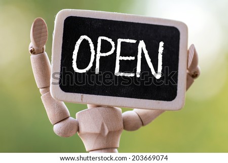 A wooden man holds a slate ready to deliver your message.Open