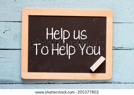 Help us to help you handwritten on blackboard lay down on wooden background
