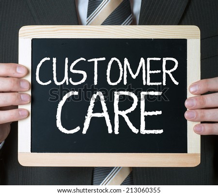 Customer care . Business man holding board on the background with business word