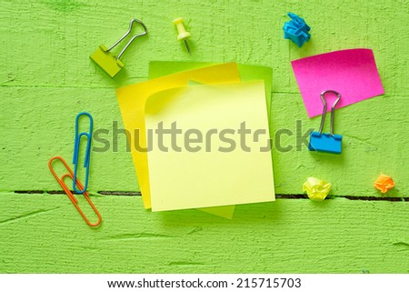 Sticky notes isolated on wooden background with clipping path pins and other office supplies . Above view.