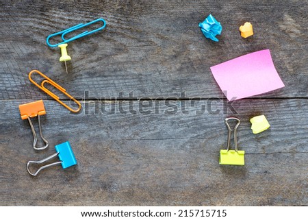 Sticky notes isolated on wooden background with clipping path pins and other office supplies . Above view.