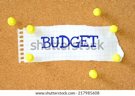 Budget on a piece of note paper pinned to a cork notice board.