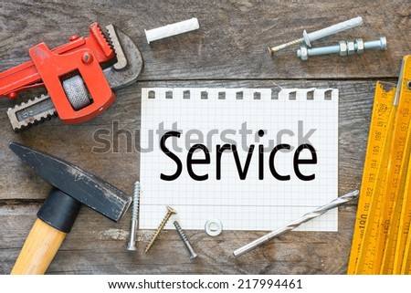 Work tools lined up on a piece of paper with text Service