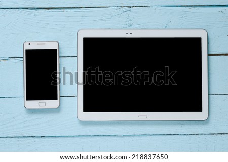 White Tablet and Smart phone. Mobile phone and Tablet pc on wooden table