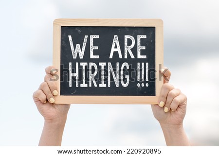 We are hiring ! Woman holding blackboard over cloudy background with text We are hiring !