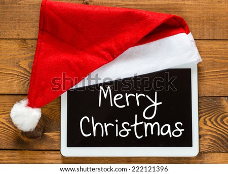 Merry Christmas. Digital tablet with Santa hat with place for greeting.