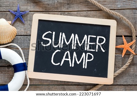 Summer camp. Marine items and blackboard with text Summer camp on wooden background. Sea objects on wooden planks.