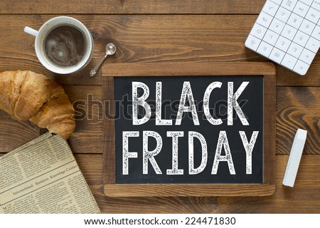 Black Friday handwritten with white chalk on a blackboard on a wooden background
