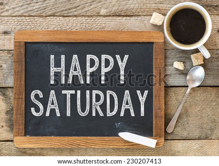 Happy Saturday sign on Blackboard. Blackboard with Happy Saturday sign and cup of coffee on wooden background