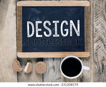 Design sign on blackboard with cup of coffee and biscuits on wooden background