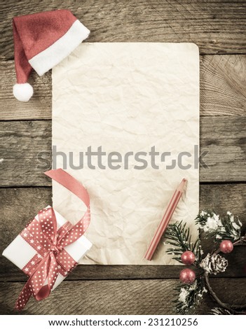 Letter to Santa Claus with Santa hat and red pencil on wooden background