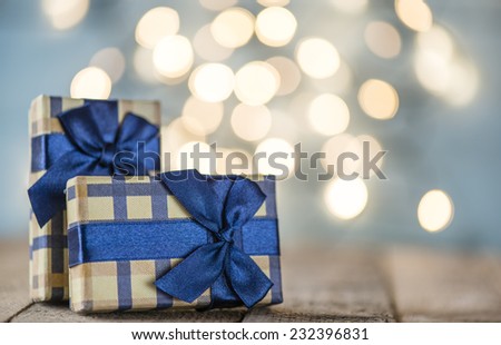 Presents with blue ribbons. Small presents with blue ribbons on sparkle blurred background.