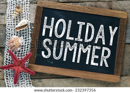 Blackboard with inscription Holiday Summer and shells on wooden background