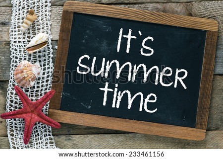 I\'s summer holiday inscription. Blackboard with I\'s summer holiday inscription and shells on wooden background.