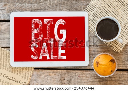 Big sale sign handwritten with chalk and coffee with muffin on a blackboard on a wooden background