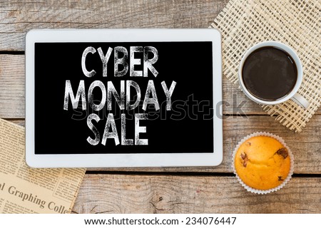 Cyber monday sale handwritten with chalk and coffee with muffin on a blackboard on a wooden background