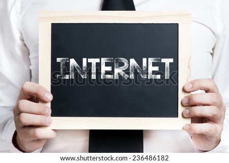Internet background . Idea. Businessman holding board on the background with internet word