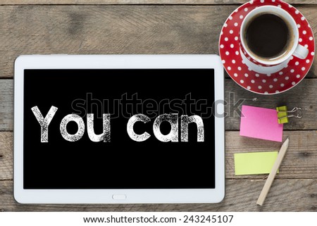 You can phrase. Tablet computer with stickers,cup of coffee and you can phrase on the wooden table