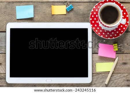 Tablet computer with stickers. Tablet computer with stickers,cup of coffee and on the wooden table