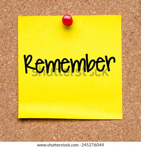 Blank note with remember. Blank yellow sticky note with remember word pined on a cork bulletin board.