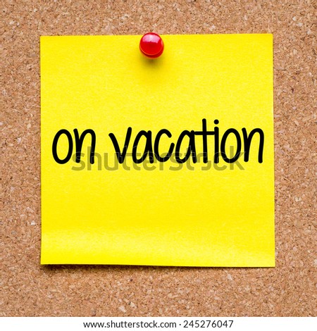 Note with on vacation. Blank yellow sticky note with on vacation pined on a cork bulletin board.