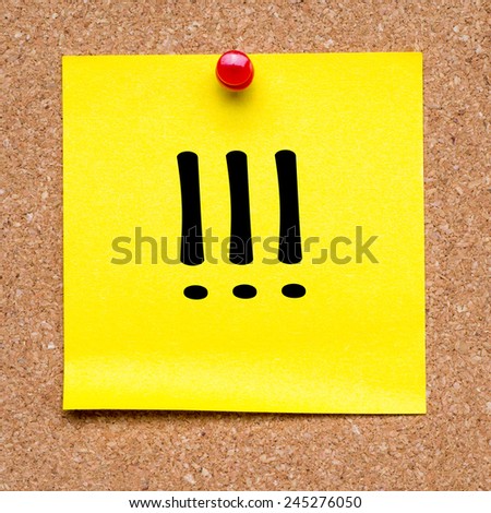 Note with exclamation marks. Blank yellow sticky note with exclamation marks pined on a cork bulletin board.