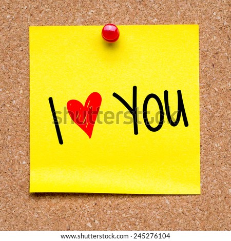 Note with I love you. Blank yellow sticky note with I love you sign pined on a cork bulletin board.