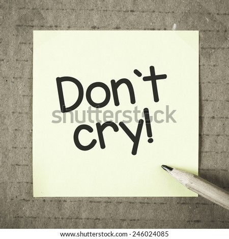 Note with don\'t cry. Note with don\'t cry and pencil on grunge background